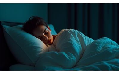 Persona en cama en una habitación oscura y silenciosa durmiendo profundamente, con luz tenue y ambiente relajante.