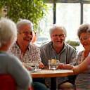 Grupo diverso de personas mayores riendo y conversando en una cafetería, mostrando conexión social